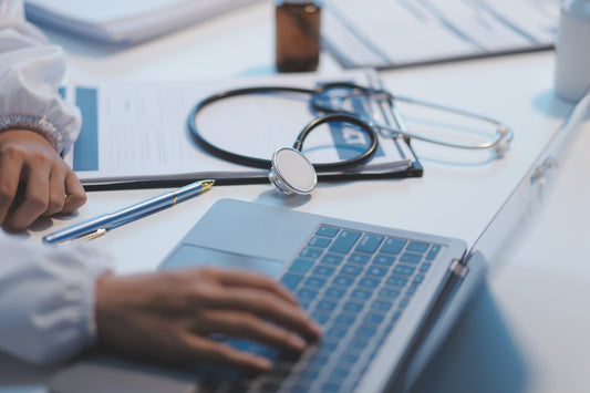 Medical office worker uses laptop to update records